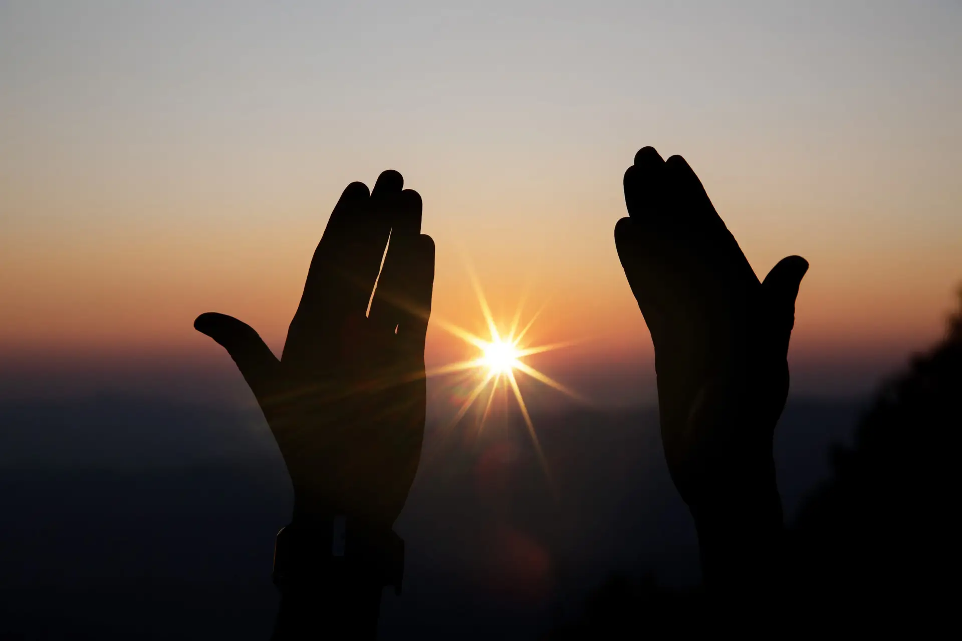 Faith of christian concept: Spiritual prayer hands over sun shine with blurred beautiful sunset background