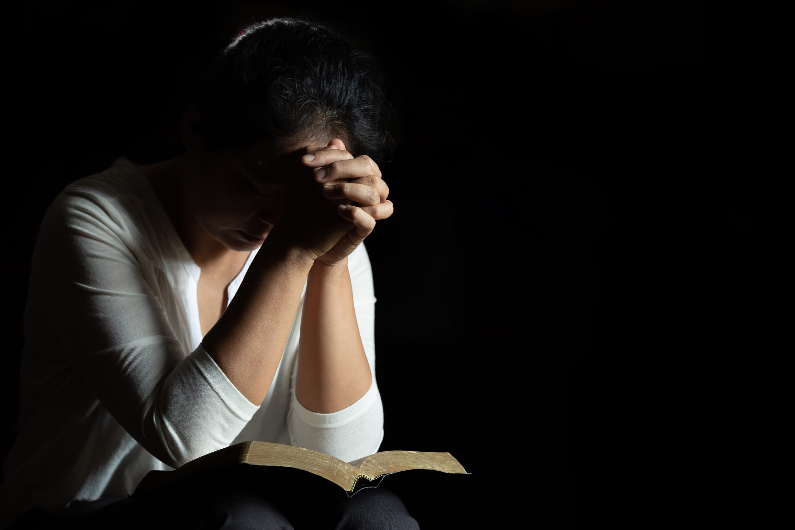 Spirituality and religion, Hands folded in prayer on a Holy Bible in church concept for faith.